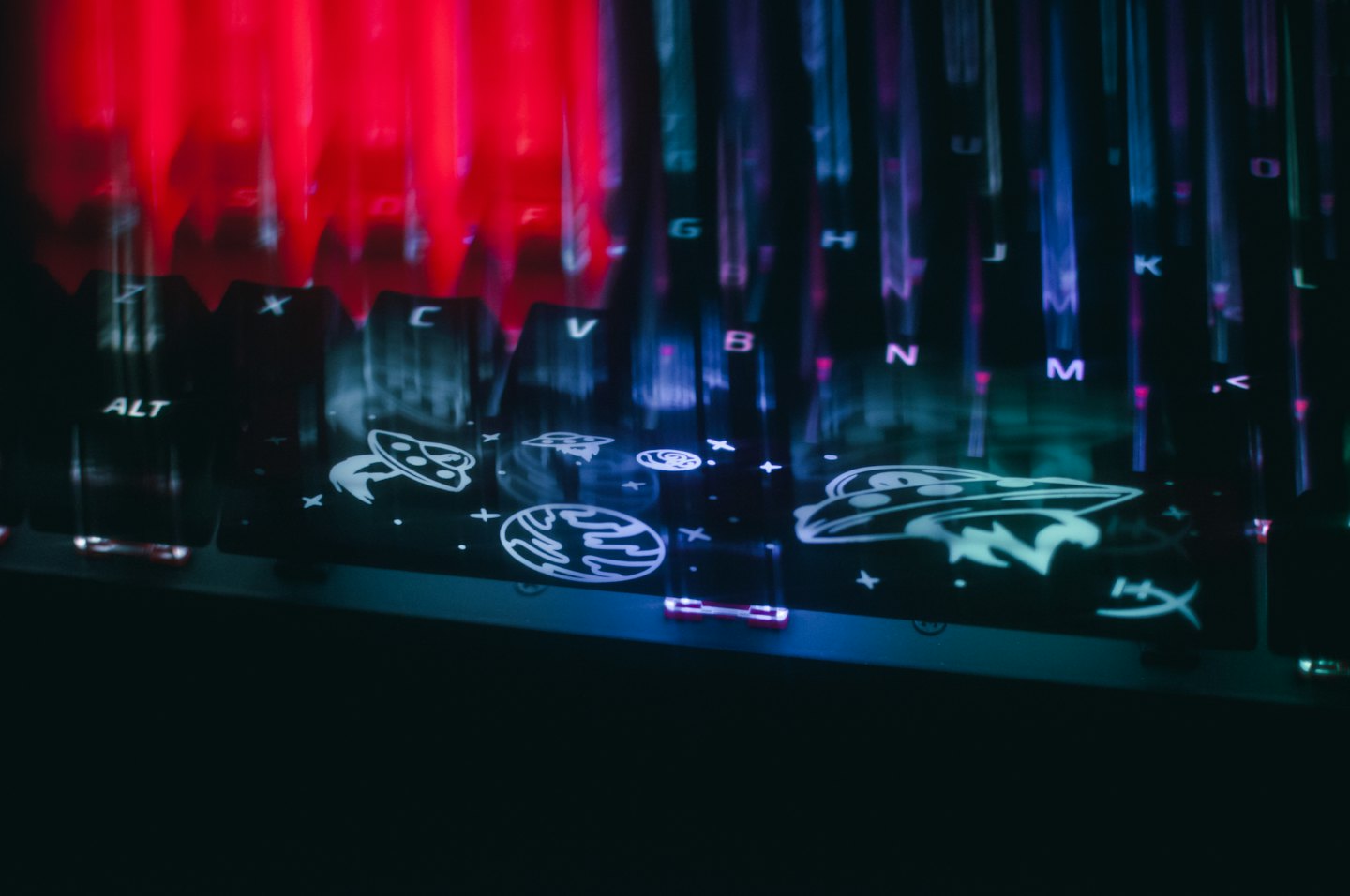 Gaming keyboard with glowing space themed keys.